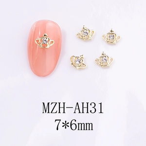 Vue macro de breloques couronne dorée pour nail art avec cristaux brillants et métal