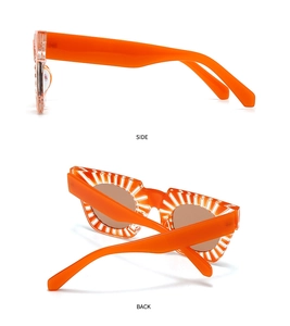 Detail view of orange square sunglasses with white radial stripes from side and back