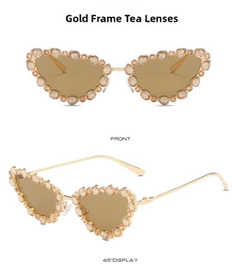 Detail view of cat eye sunglasses with gold metal frame and tea colored crystals