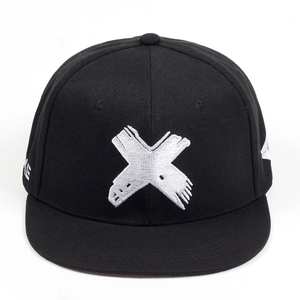 Close-up of black flat brim cap with white X embroidery and cotton twill texture