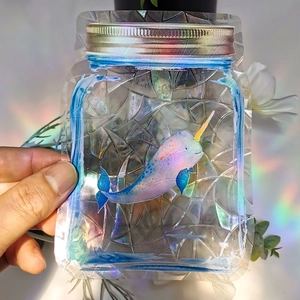 Rainbow narwhal suncatcher sticker with geometric mosaic texture in retail packaging