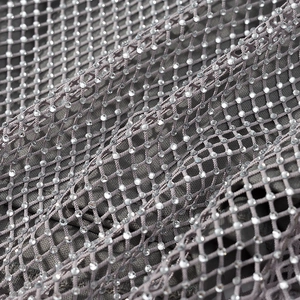 Détail macro du tissu en maille grise orné de strass brillants et étincelants