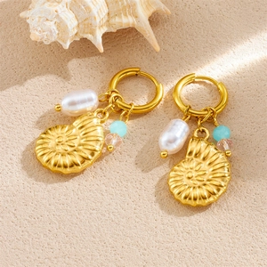 Boucles d'oreilles conque dorée avec perle irrégulière et perles colorées sur sable