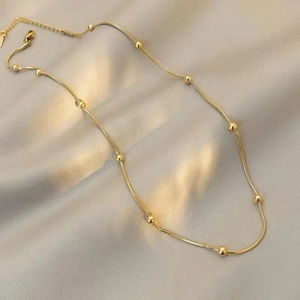 Elegant rose gold beaded snake chain necklace displayed on premium champagne silk fabric