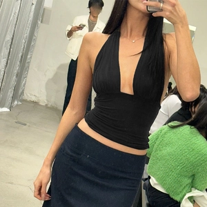 Mirror selfie showing the detail of a black V-neck halter top with elastic fabric texture