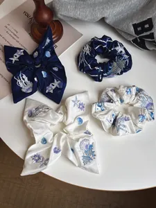 Macro detail of blue and white hair scrunchies with intricate sea life embroidery patterns