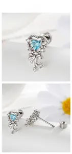Detailed view of silver heart key stud earrings with blue zircon and bow detail
