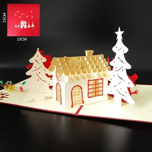 Detail of 3D pop-up Christmas card featuring laser-cut gold and white house in snowy forest