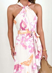 Détail d'une robe licou élégante à motifs floraux roses avec une ceinture nouée à la taille