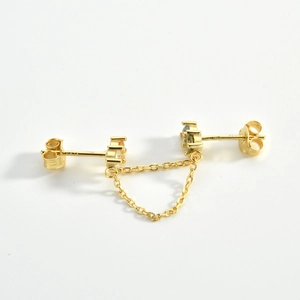 Detailed macro view of S925 gold earrings featuring dual studs connected by fine chains