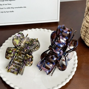 Large acetate bow hair claws with marble texture set on decorative ceramic plate