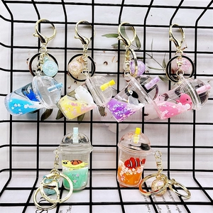 Detail of colorful liquid quicksand acrylic milk tea cup keychains with cartoon charms
