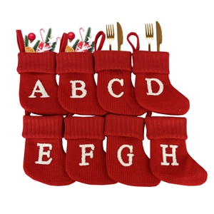 Set of 8 red knitted Christmas stockings with white embroidered letters A to H for decor