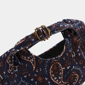 Detail of vintage paisley corduroy cap showing adjustable brass metal buckle strap