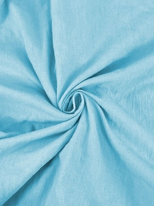 Detail of light blue linen fabric texture showing natural drape and soft spiral folds