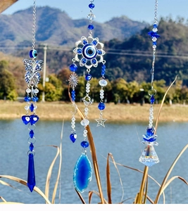 Detail of blue evil eye butterfly suncatcher with crystal prisms and agate hanging ornaments