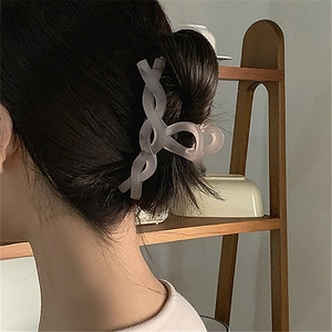 Pinza de pelo de plástico gris mate translúcido mostrada en un moño de una modelo