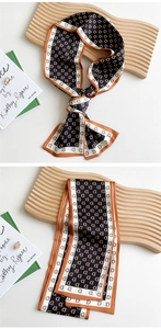 Detail of a navy and orange twilly silk scarf featuring geometric letter D patterns