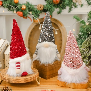 Trois gnomes de Noël à paillettes rouge, gris et rose avec des lumières chaleureuses