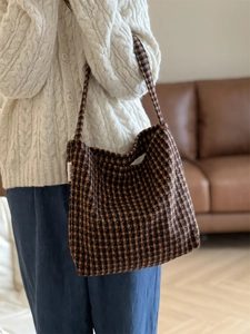 Detail of checkered woolen tote bag texture with orange and brown woven pattern