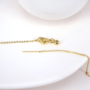 Fine gold necklace featuring a lobster clasp closure and small round bead pendant