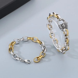 Dettaglio del bracciale a catena punk in acciaio inossidabile bicolore con croce