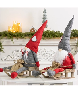 Detail of Christmas gnomes with wooden sleigh bases on a festive fireplace mantel decor