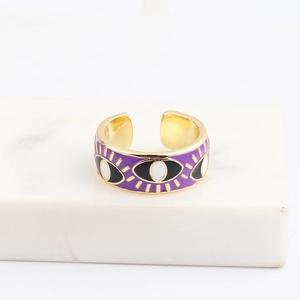Detailopname van een paarse emaille evil eye ring op een wit marmeren standaard