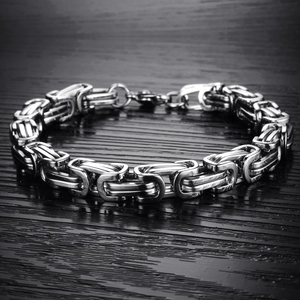 Polished silver stainless steel Byzantine chain bracelet with lobster clasp on wood