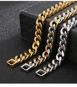 Close-up of gold and silver stainless steel Cuban link bracelets with secure square clasps