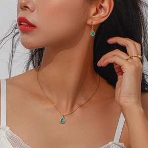 Detail view of water drop teardrop necklace set with teal gemstone inlay on gold metal