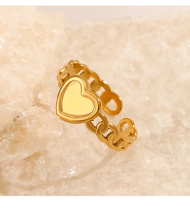 Detail of golden heart-shaped open ring with chain band design on crystal rock