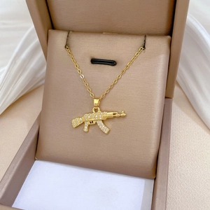 Macro view of AK-47 assault rifle pendant with sparkling cubic zirconia on a gold chain