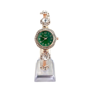 Rose gold ladies watch with green dial, sparkling rhinestones, and adjustable strap on stand