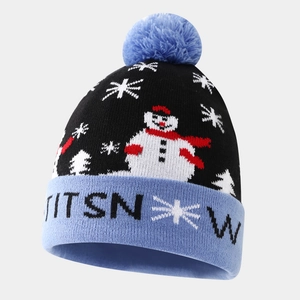 Macro detail of knit winter beanie featuring snowman patterns and blue faux fur pom-pom