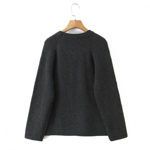 Detail of dark grey knit sweater showing ribbed texture and seamless raglan sleeves