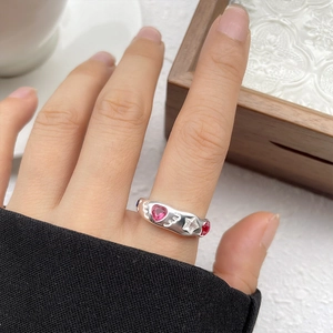 Detail of 925 silver ring with pink heart, white star stones and wavy textured band