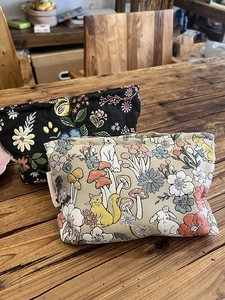 Detailed top view of floral and animal pattern canvas makeup bags on a wooden table