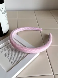 Detail of pink plaid pattern headband with thick sponge texture on beige tile surface