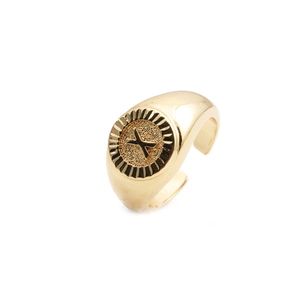 Macro shot of gold-plated copper letter X ring detail with a distinct embossed design