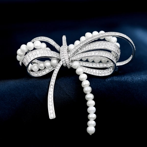 Elegant silver bow brooch with micro-paved zircons and white pearls on blue silk