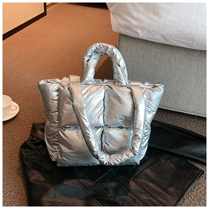 Macro shot of silver quilted puffer tote bag with large square padded panels