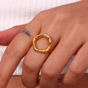 Detail of gold lava style irregular hollow ring with metallic luster on model finger
