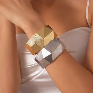 Close-up of geometric faceted metal bangle with intricate sunburst etched texture for women