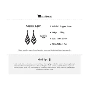 Detail view of long geometric tassel earrings with zircon inlay and silver needle posts