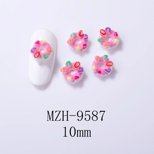 Detailed view of pink resin donut nail charms with LOVE lettering and star patterns
