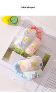 Detail of hand-painted embossed ceramic mugs with colorful bubble handles on a book