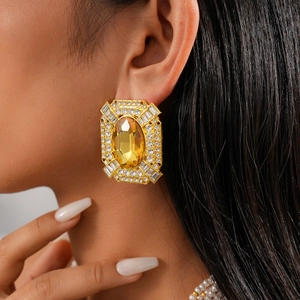 Close-up of vintage geometric gold earrings with yellow crystal and sparkling rhinestones