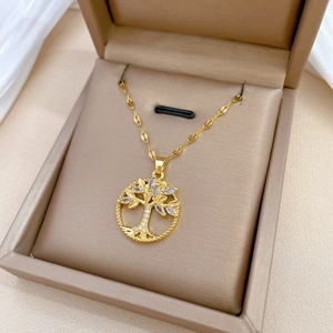Luxurious gold Tree of Life necklace with sparkling crystals in a beige jewelry box