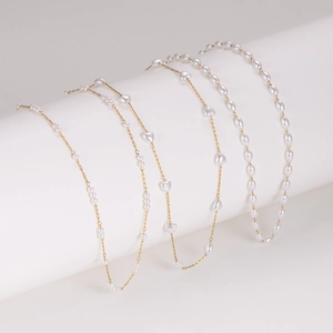 Elegant gold pearl necklace set with heart and oval shapes on white display